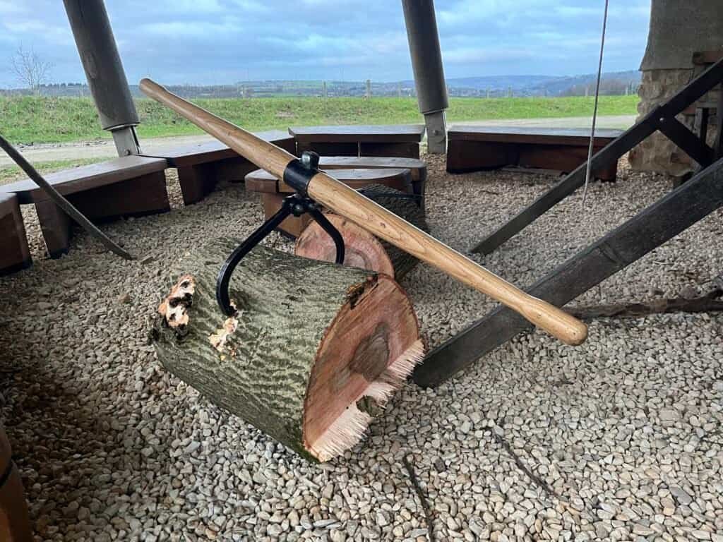 Pruning axe on a log, biodynamic farming tools for sustainable vineyard management.